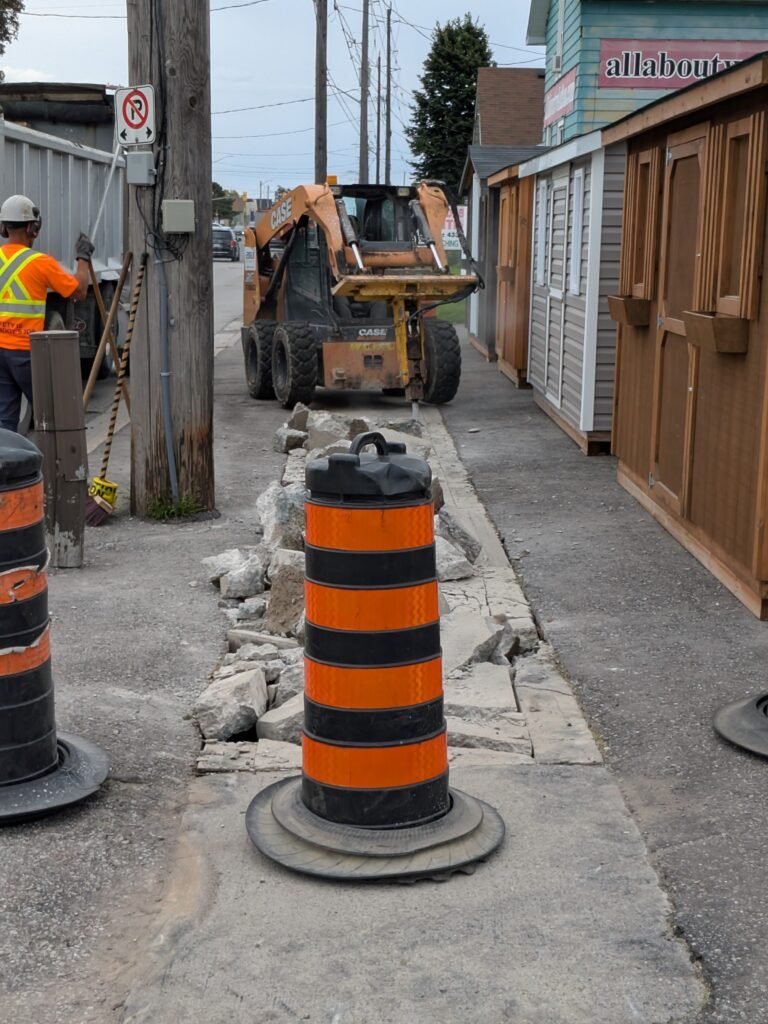 Who Is Paying for Oshawa Sidewalk Work on Bloor Street East? Skid-steer removing sidewalk concrete beside businesses on Bloor Street East in Oshawa